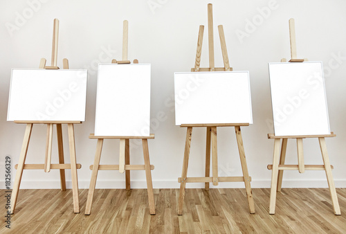 Four art studio easels with blank white frames to add paintings or pictures 