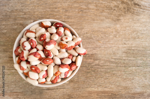 Сolorful kidney beans in the bowl on a wooden table. Spae for text photo