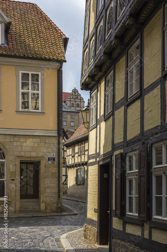 QUEDLINBURG, GERMANY – August 16, 2017: View through the narrow lane of Lange Gasse in the Old Town of Quedlinburg, Saxony-Anhalt, Germany.
