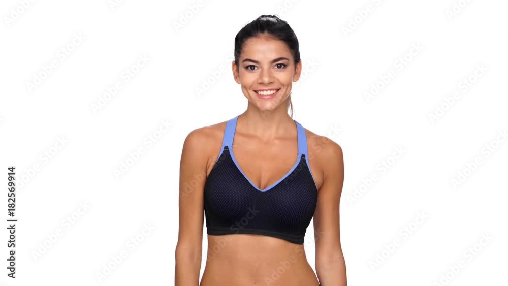 Happy brunette fitness woman showing thumbs up at camera over white background Happy brunette fitness woman showing thumbs up at camera over white background