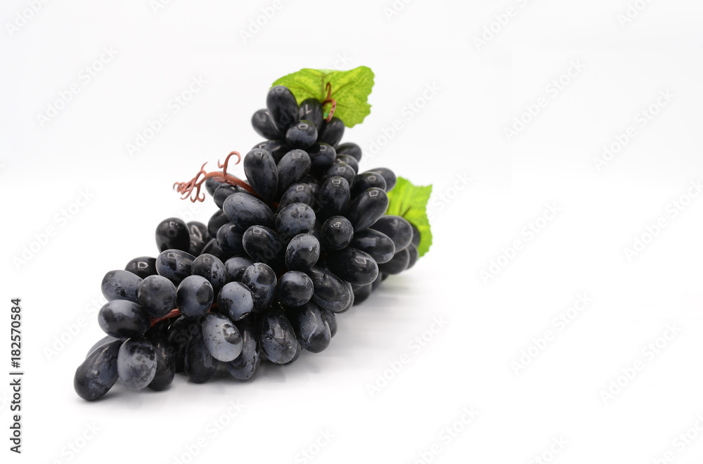 Fake violet grapes on white background with green leafs Fake violet grapes on white background with green leafs