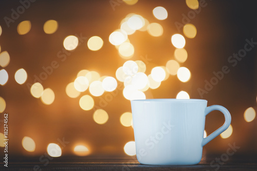 White cup of tea or coffee and Christmas Lights