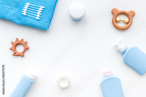 Natural bath cosmetics for kids. Bottles, towel and toys on white background top view copyspace