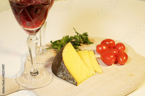 pieces yellow cheese and small red tomatoes with wine