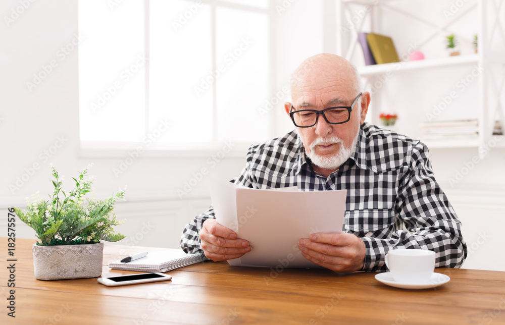 Senior man reading news on digital tablet