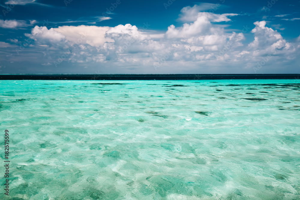 Clear ocean water and a cloudy blue sky