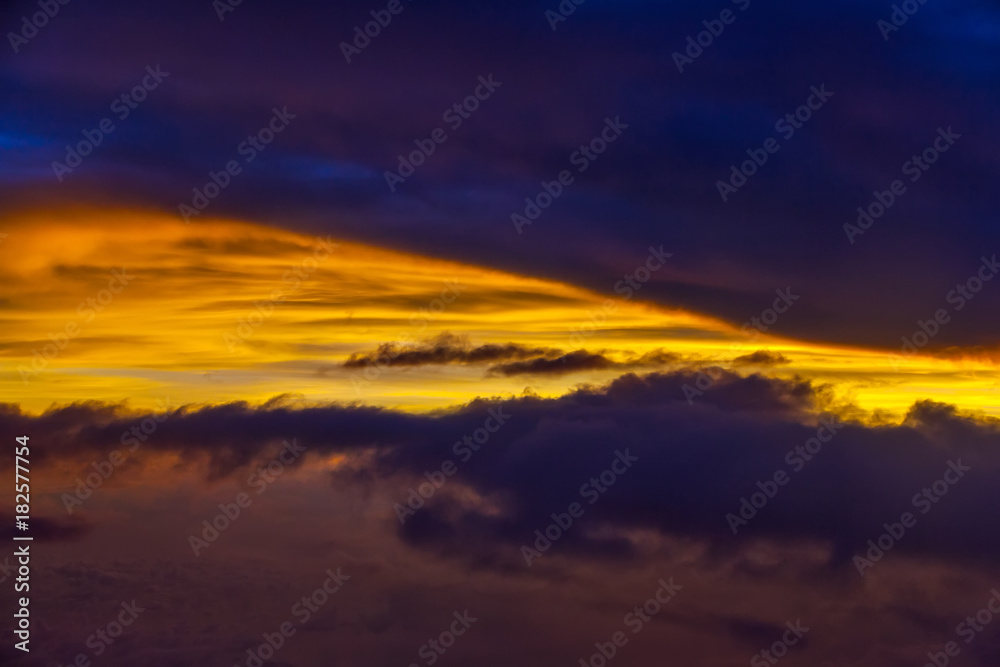 A colorful sunset in the clouds, a stunning natural phenomenon. Skyscape from the plane, at an altitude of 10,000 meters.