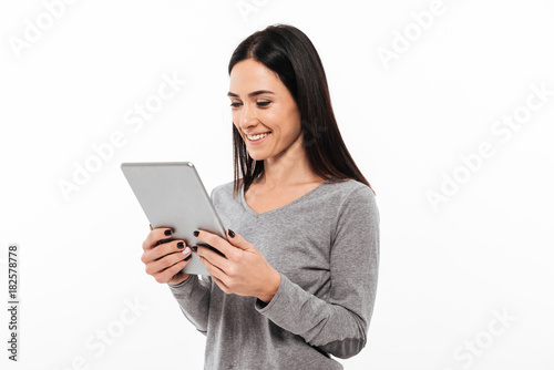 Wallpaper Mural Happy woman standing isolated using tablet computer. Torontodigital.ca