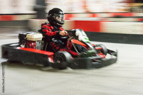Foto Cart (kart) blurred by high speed, a boy having fun - driving fast, racing, speeding