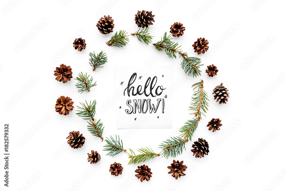 Hello snow hand lettering. Winter pattern with pinecones and spruce branch on white background top view