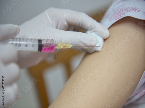 Soft focus nurses are vaccinations to patients using the syringe.Doctor vaccinating women in hospital.Are treated by the use of sterile injectable upper arm. injection