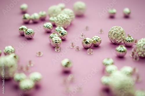 selection of scattered silver beads on pink background