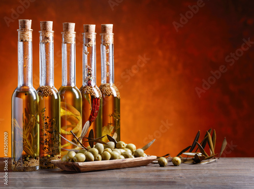 Green olives and bottles of olive oil .