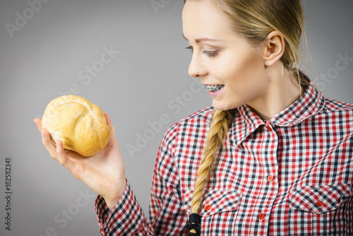 Woman holding bun bread roll.