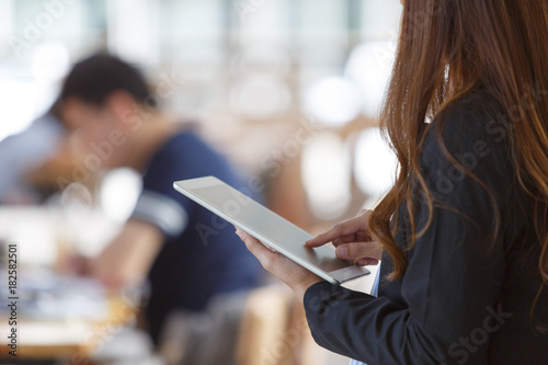 Close-up of female hands typing on touch screen of digital tablet outside, Business woman using a tablet in the office.