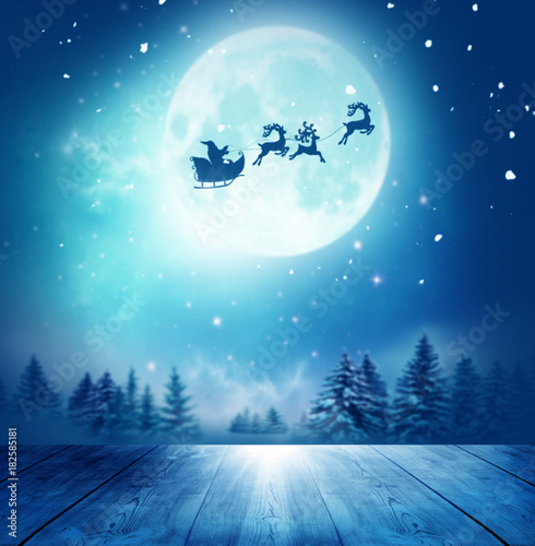 Merry christmas and happy new year greeting card with table. Santa and his sleigh flying over snowy landscape