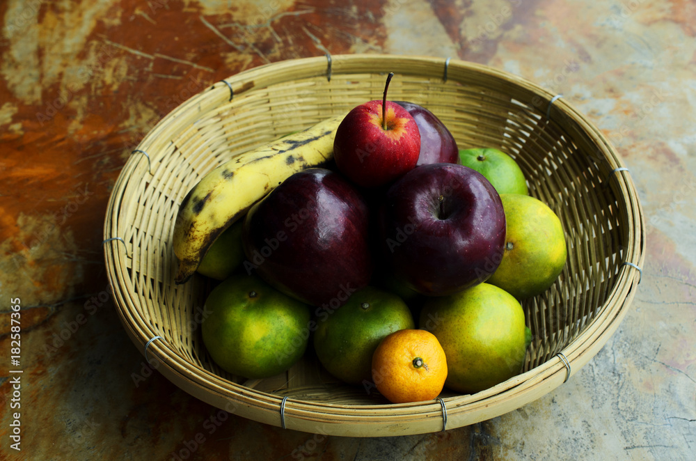 Still life fruts with apple banana and orange in basket weave on wooden table Still life fruts with apple banana and orange in basket weave on wooden table