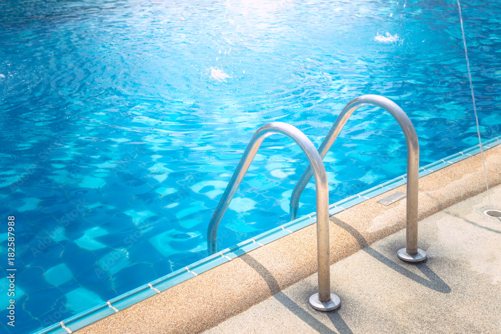 Grab bars ladder in the blue swimming pool