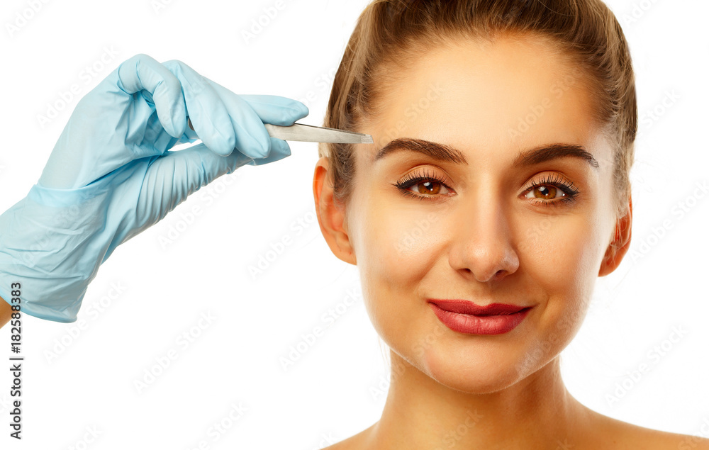 Young beautiful woman with tweezers over white background