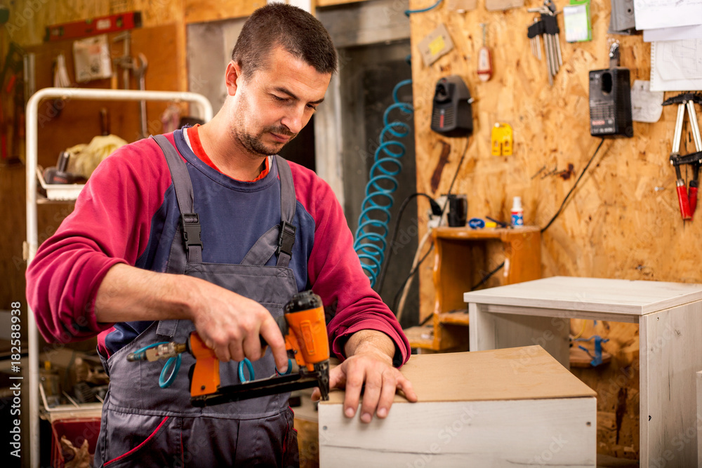 Man builds furniture in the carpentry shop Man builds furniture in the carpentry shop