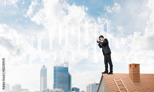 Businessman standing on roof and looking in binoculars. Mixed media