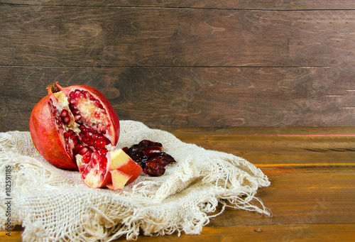 pomegranate, dates on sacking and wooden background