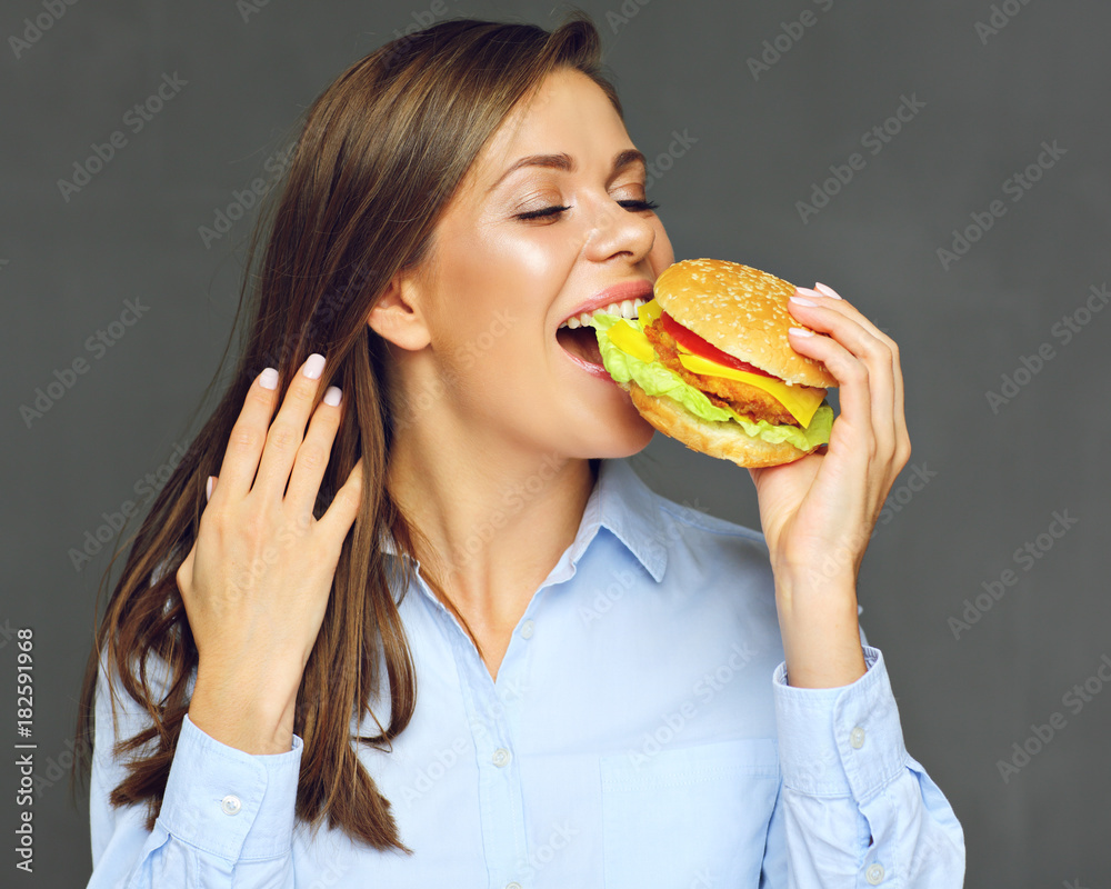 Close up face portrait of woman biting burger. Close up face portrait of woman biting burger.
