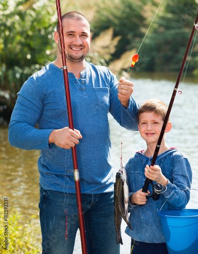Portrait of father and son fishing with rods