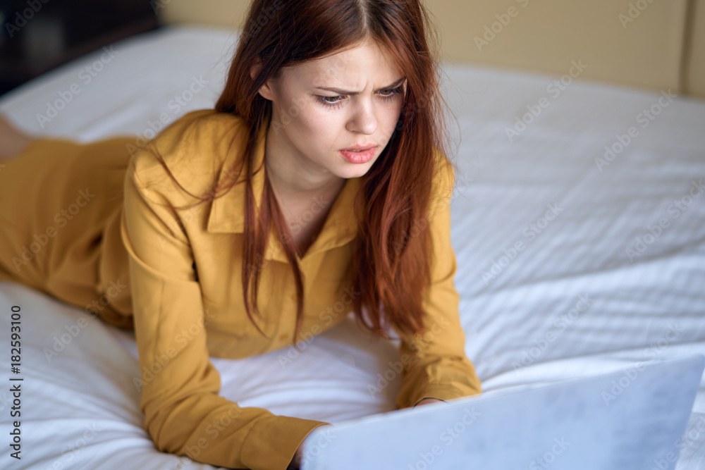 A girl in a yellow dress lies on a white bed A girl in a yellow dress lies on a white bed