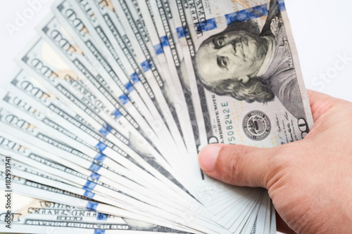 Close up hand holding money of one hundred dollar bills isolated on white background.