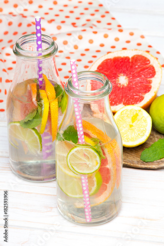 Infused flavored water with fresh fruits on white wooden background.Refreshing summer homemade  detox water