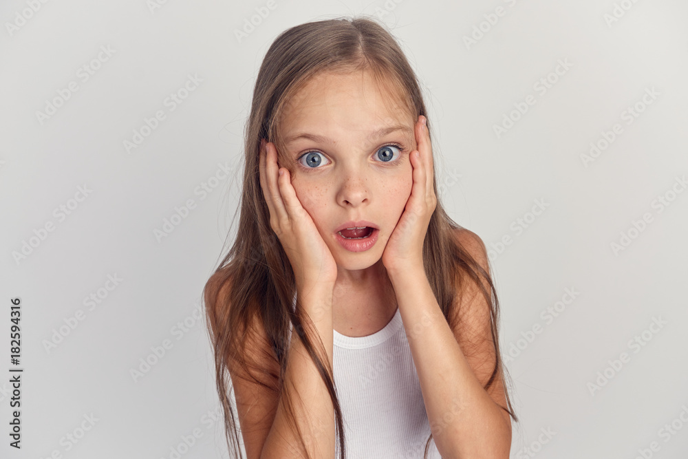 little girl on a gray background surprised little girl on a gray background surprised