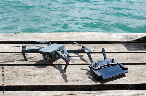 Drone and remote controler on wooden pier, ready to fly