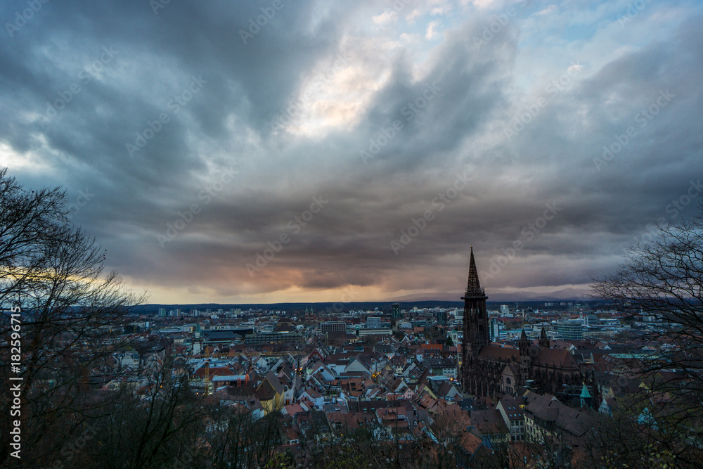 Romantic orange sunset above the City of Freiburg in Germany with the ancient church building