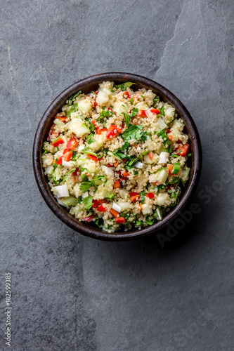 Traditional peruvian quinoa quinua salad in clay bowl, slate gray background