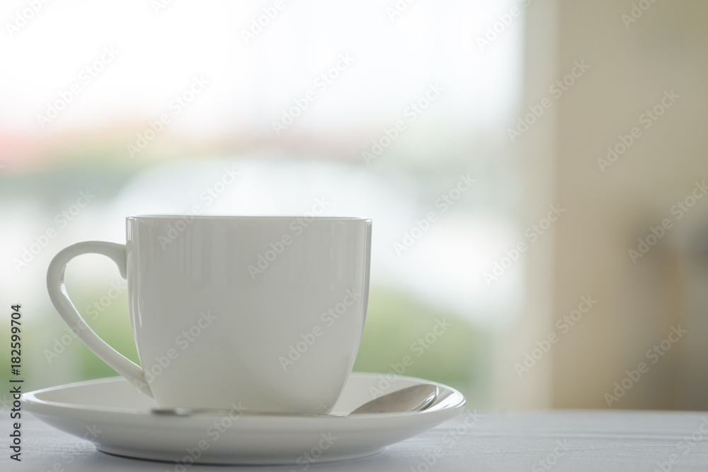 Cup of coffee placed on white table and blurred garden background. Cup of coffee placed on white table and blurred garden background.