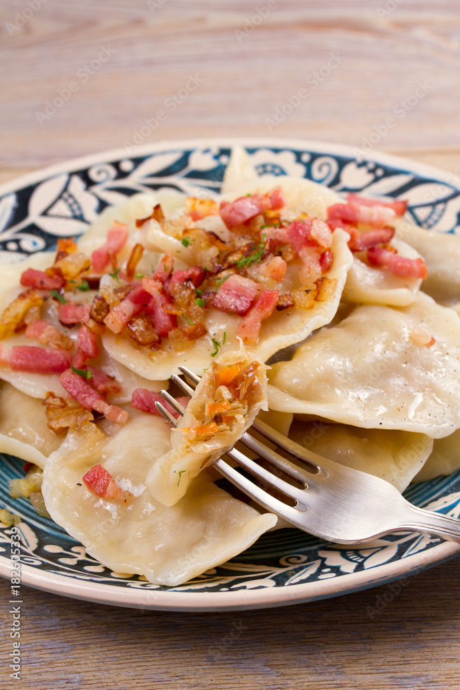 Dumplings, filled with cabbage and served with fried bacon and onion. Varenyky, vareniki, pierogi, pyrohy - popular dish in East Europe