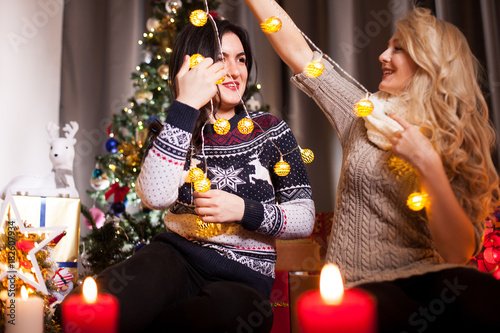 Happiness and friendship. Two women in christmas eve having fun in decorated house