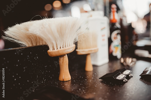 brush for shaving a beard along with a bowl, a blurred background of a hair salon for men, a barber shop