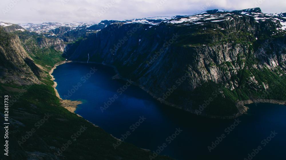 Beautiful summer vibrant view on famous Norwegian tourist place - trolltunga, the trolls tongue with a lake and mountains, Norway, Odda.