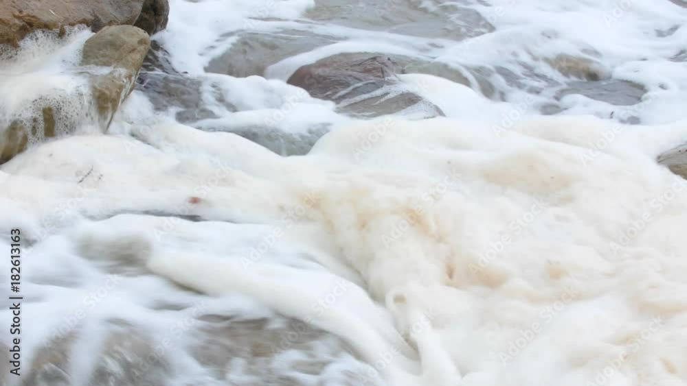 Foam on the ocean shoreline in rough water from a storm Foam on the ocean shoreline in rough water from a storm