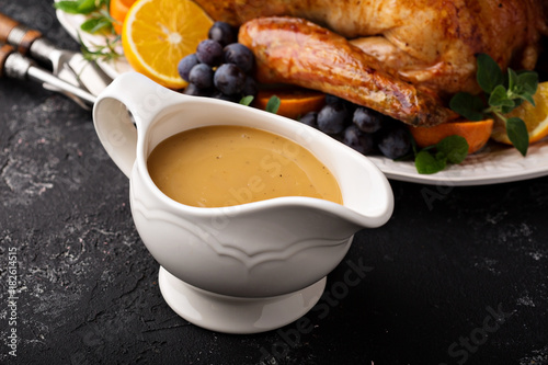Homemade gravy in a sauce dish with turkey photo