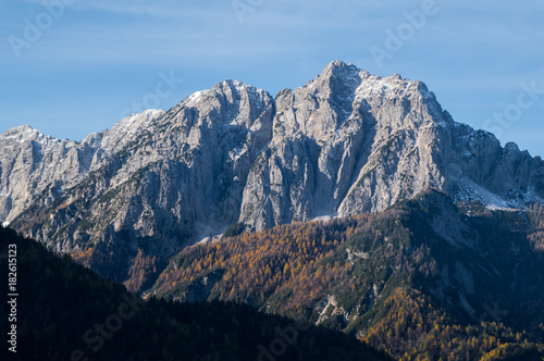 Early morning sun rays hitting the Jalovec mount in Slovenia's Julian Alps