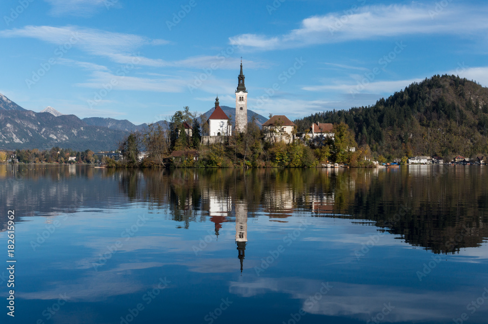 The church on the island in the middle of lake Bled reflecting perfectly in its waters