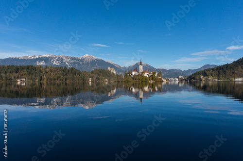 Far away dhot of Bled island and church, complete with mountains and castle in the background