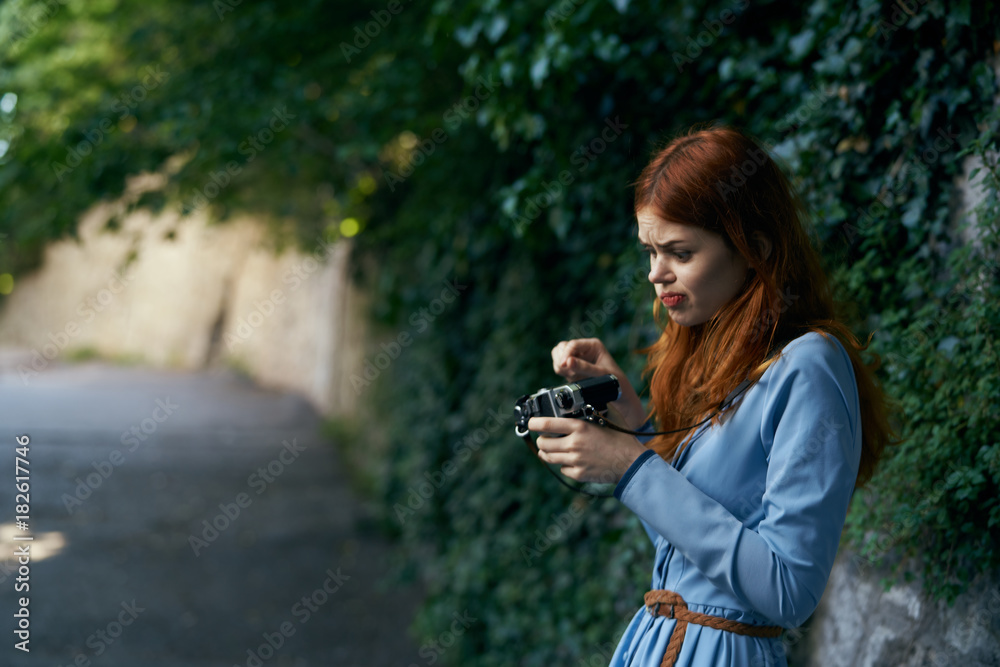 a woman trying to fix a camera on the street a woman trying to fix a camera on the street