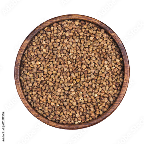 Buckwheat groats in wooden bowl isolated on white background