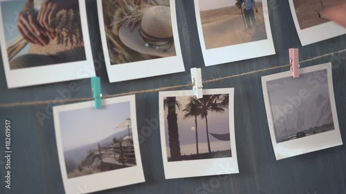 Woman hanging photo of her travel on the wall, vacation photos.