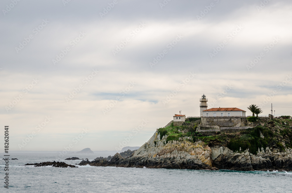 With a turquoise water in front the Lighthouse of Cudillero in Asturias is one of the most beautiful places in the North of Spain