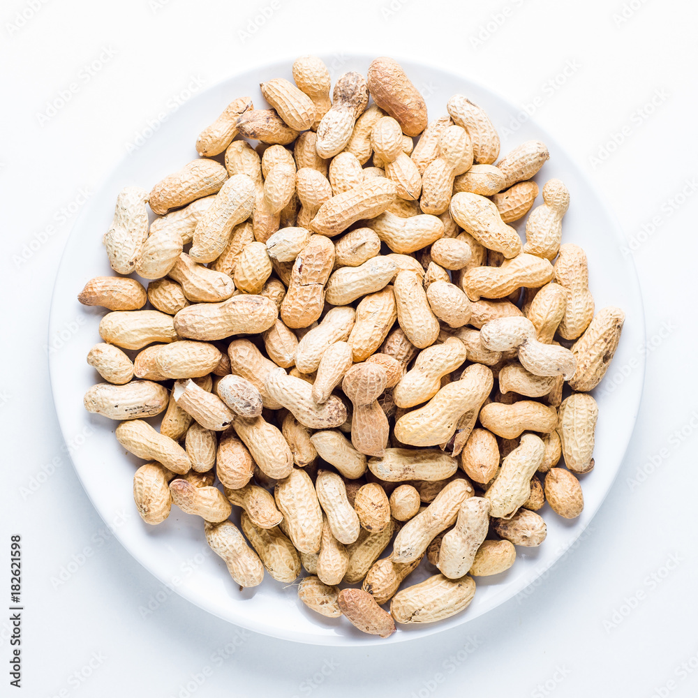 Raw peanuts in a plate on white background Raw peanuts in a plate on white background